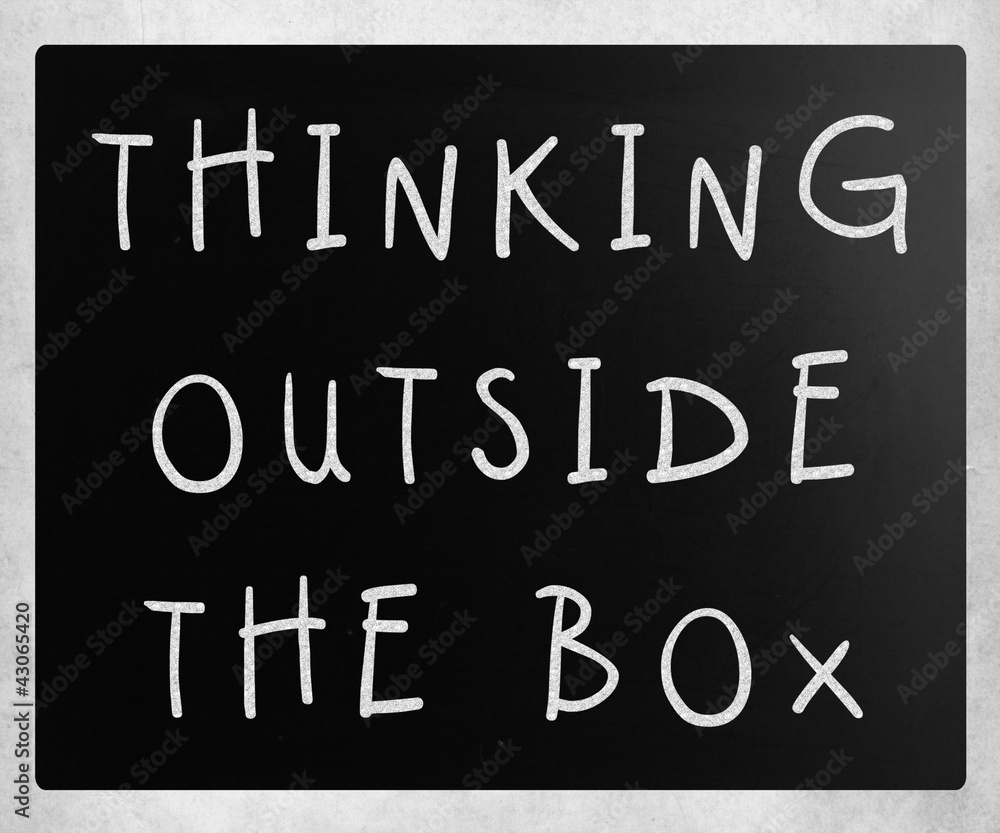 Thinking outside the box phrase, handwritten with white chalk on Thinking outside the box phrase, handwritten with white chalk on