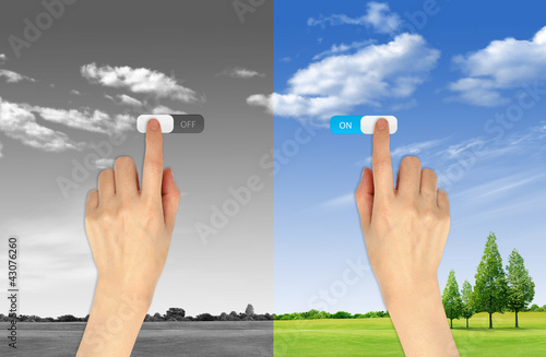 Hand press on and off button on landscape background for green e
