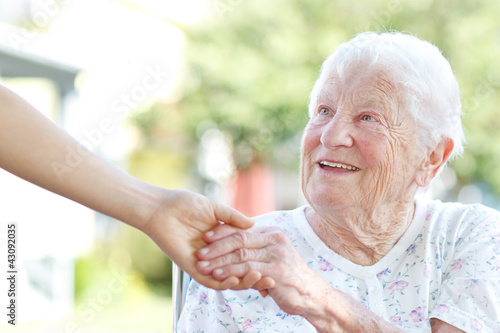 Senior woman holding hands with caretaker