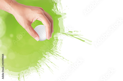 Close-up of hand holding golf ball with green grass for web desi