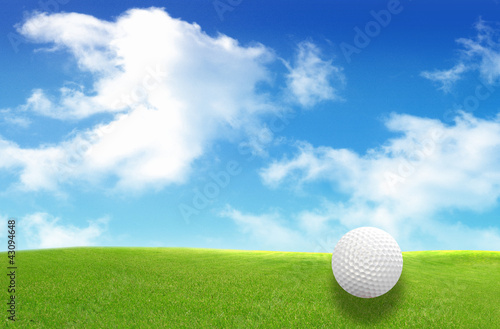 Close-up of golf ball with green grass and blue sky for web desi