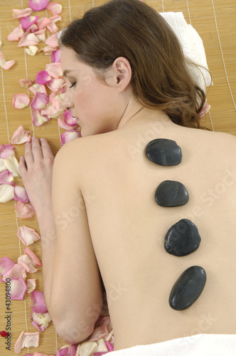 young woman getting a stone massage in spa