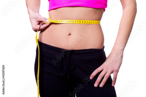 a slim girl measuring her waist - closeup, isolated