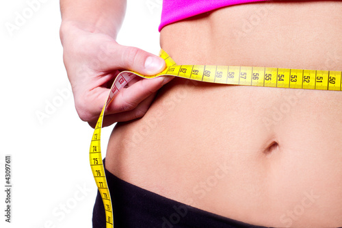 slim girl measuring her waist - closeup, isolated