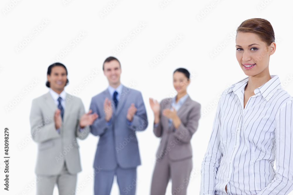Close-up of a woman with business people applauding while watchi Close-up of a woman with business people applauding while watchi