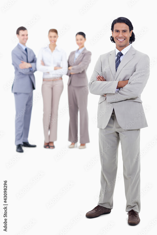 Businessman smiling and crossing his arms with happy people behi Businessman smiling and crossing his arms with happy people behi