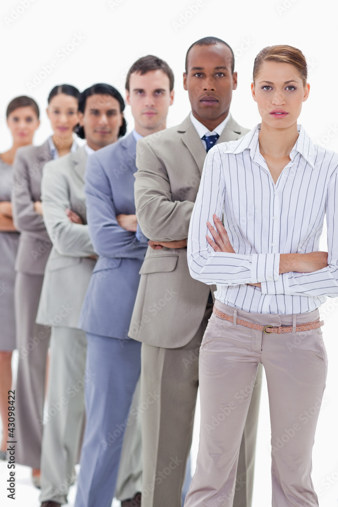 Serious colleagues dressed in suits crossing their arms in a sin Serious colleagues dressed in suits crossing their arms in a sin