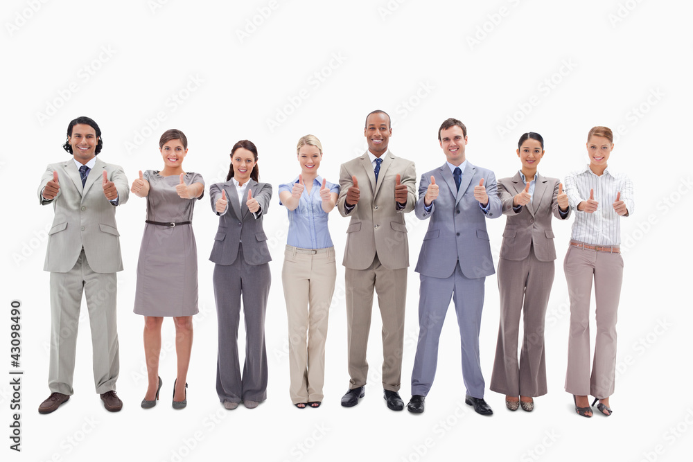 Smiling business team side by side with their thumbs up Smiling business team side by side with their thumbs up