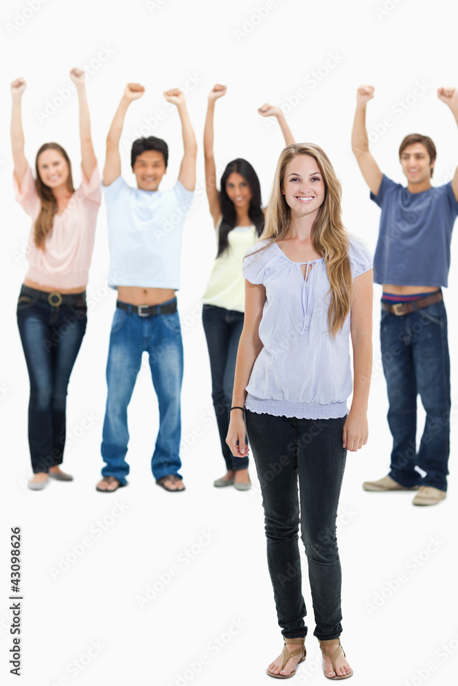 Woman smiling with people with their arms raised behind her Woman smiling with people with their arms raised behind her