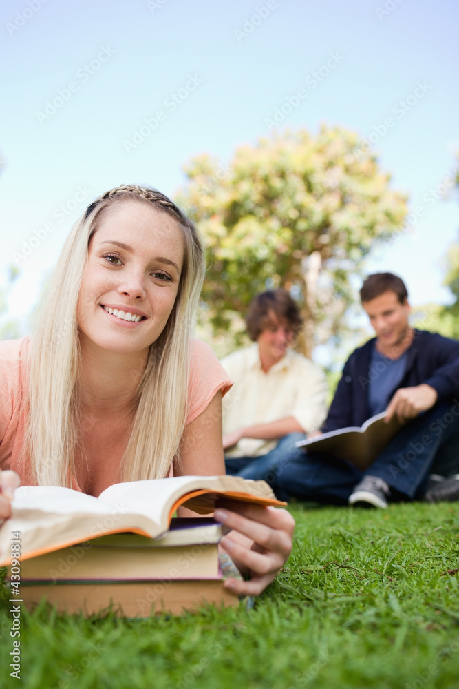 Portrait of a girl lying while reading books in a park Portrait of a girl lying while reading books in a park