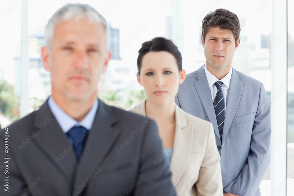 Young serious executive following his business team Young serious executive following his business team