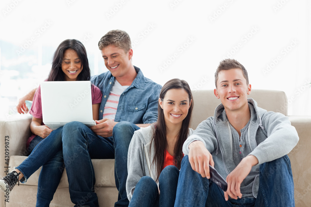 A man and woman sitting on the ground while another man and woma A man and woman sitting on the ground while another man and woma