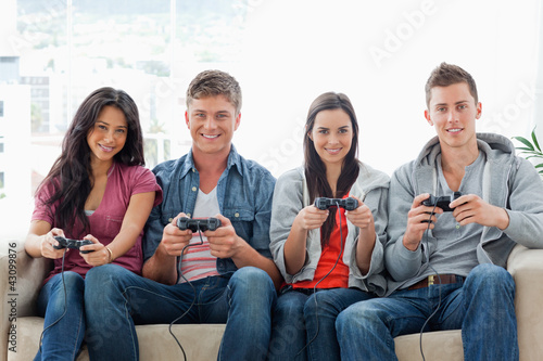 A group of friends play games while on the couch