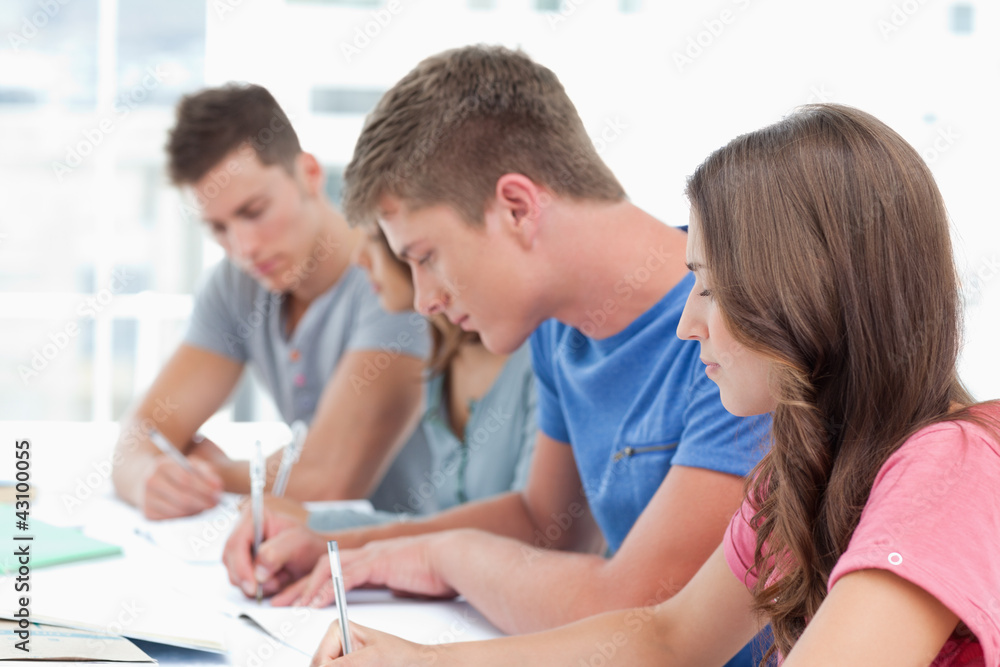 Side view of four students working together Side view of four students working together