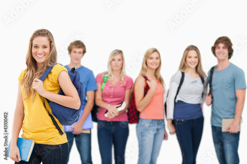 A woman standing in front of his friends as she smiles