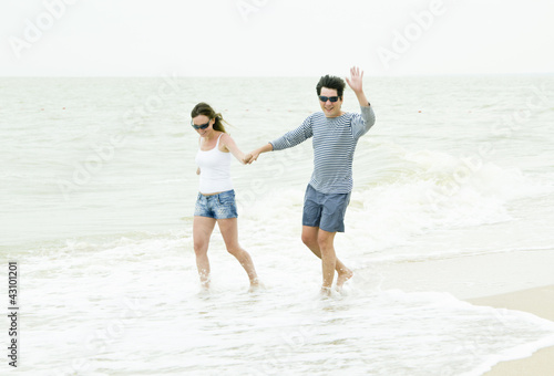 Happy couple enjoying together at the beach