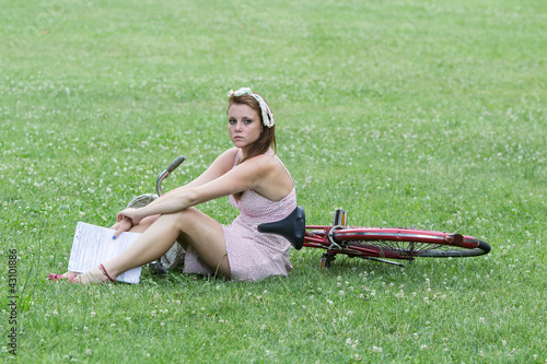 Obraz na płótnie Beautiful girl with her bicycle, in a relaxing garden w salonie