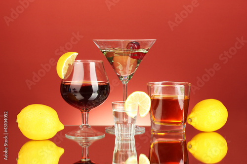 a variety of alcoholic drinks on red background