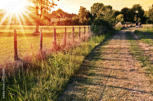 Paysage de campagne française au coucher du soleil, chemin et clôture dans les champs à Vaas, Sarthe - France
