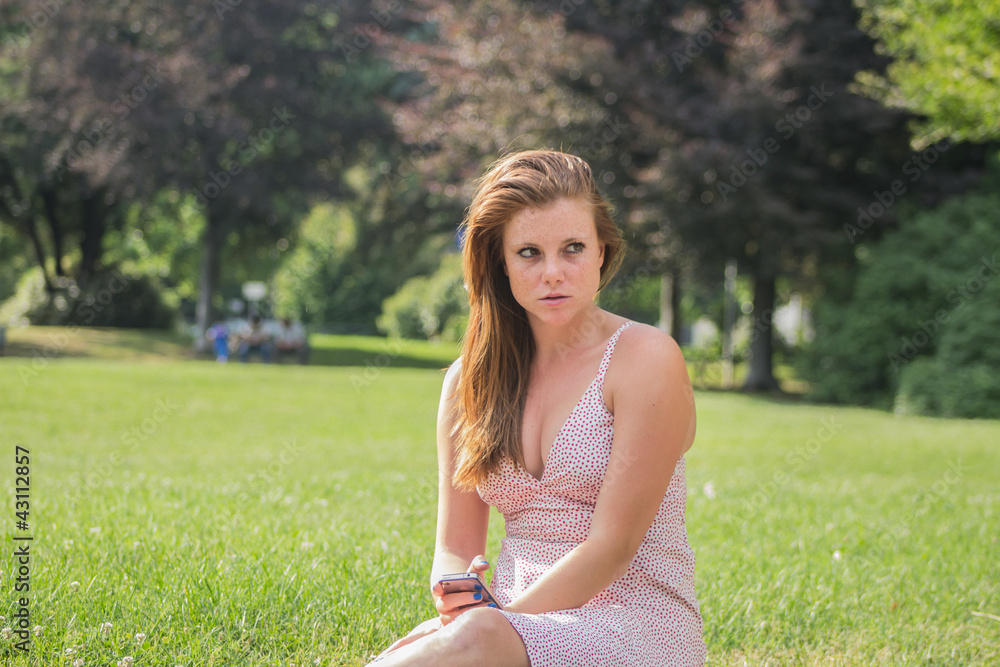 Beautiful girl with red hair, relaxing at campus