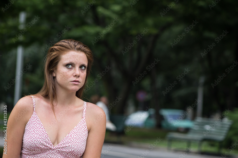 Beautiful thoughtful girl in a campus, with red hair