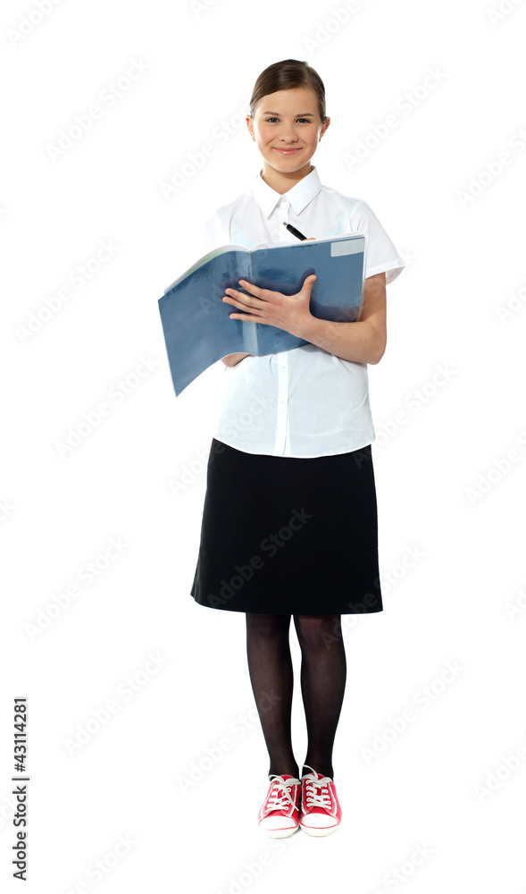 Full length portrait of smiling girl doing homework Full length portrait of smiling girl doing homework