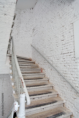 Escalier blanc sur mur blanc.