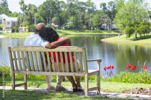 Senior African American Couple Sitting On Park Bench