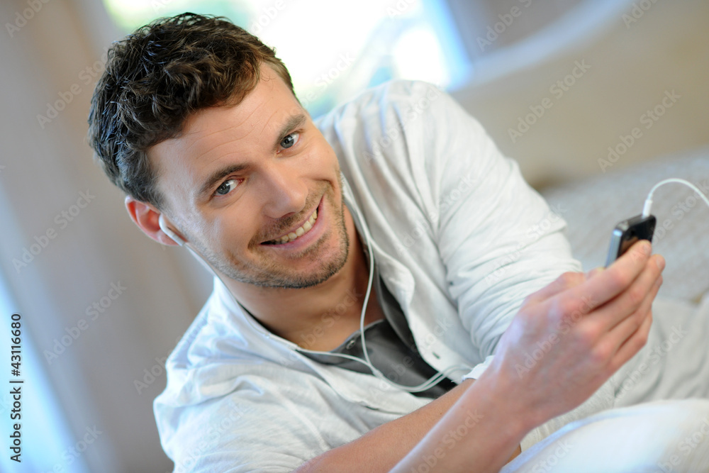 Obraz premium Young man listening to music on smartphone