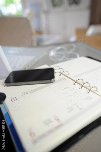 Closeup of smartphone and agenda set on table
