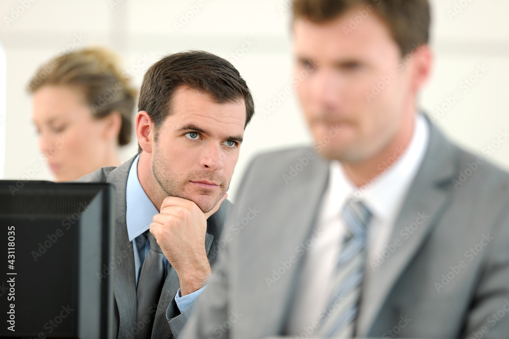 Office worker sitting in front of desktop Office worker sitting in front of desktop