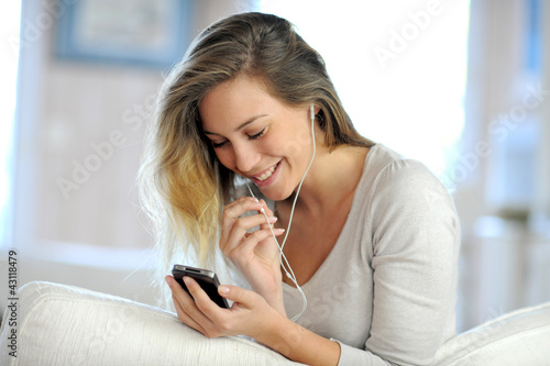 Beautiful young woman using handsfree device on mobile phone