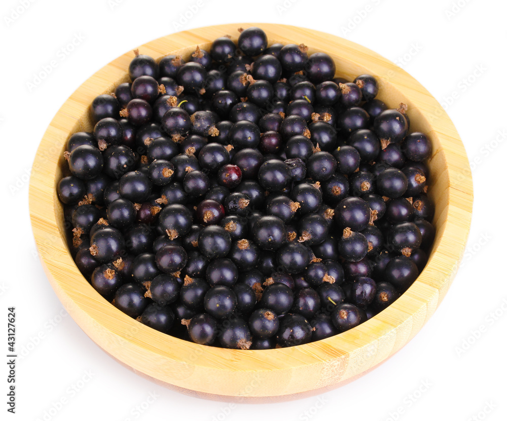 Black currant in wooden bowl isolated on white Black currant in wooden bowl isolated on white