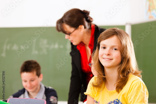 Schulkinder und Lehrerin lernen an der Schule