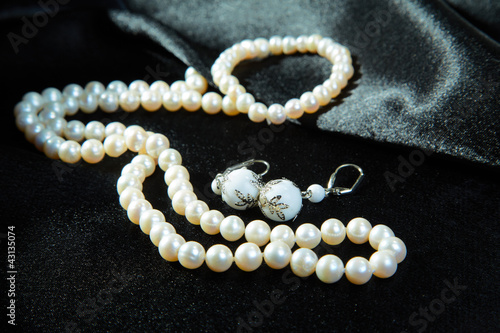 White necklace and earrings on a black