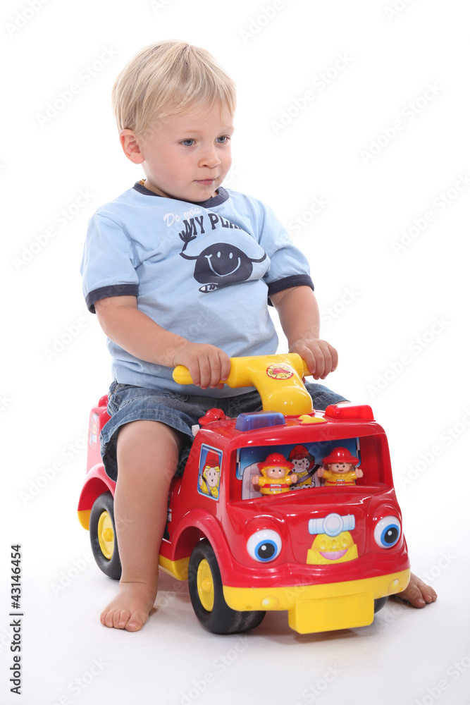little boy sitting on a toy car little boy sitting on a toy car