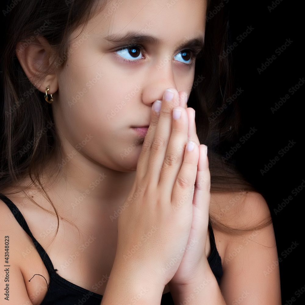 Postrait of an hispanic girl praying isolated on black Postrait of an hispanic girl praying isolated on black