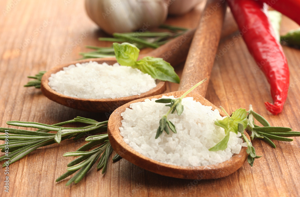 salt in spoons with herbs and vegetables isolated on white salt in spoons with herbs and vegetables isolated on white