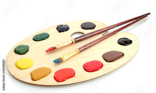 wooden art palette with paint and brushes.isolated on white