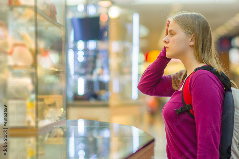 Young woman in front of shopping windows in mall