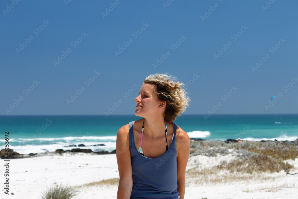 Frau am Strand mit Wind in den Haaren