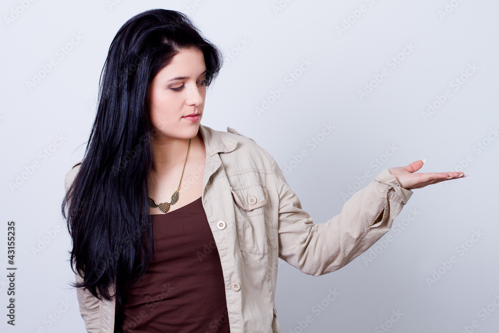 beautyful young woman holding, showing something in her palm beautyful young woman holding, showing something in her palm