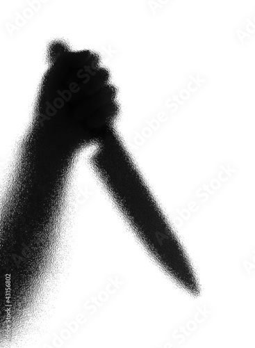 Foto Knife in a hand. Silhouette. Photographed through the textured g
