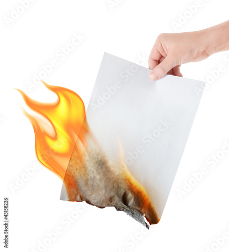 фотографія burning paper in hand on white background