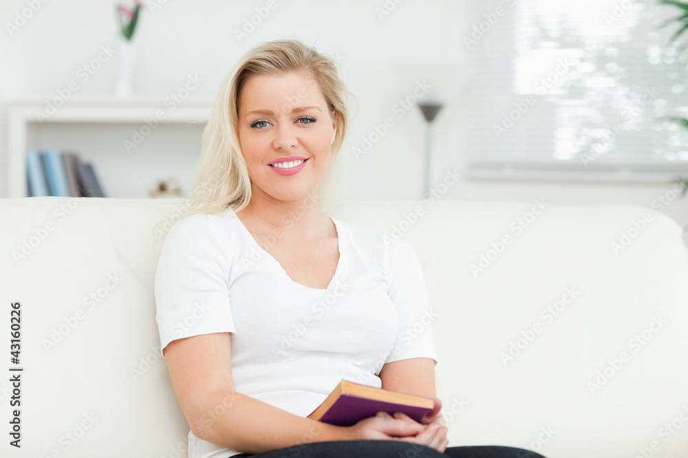 Woman sitting on a sofa with a book Woman sitting on a sofa with a book
