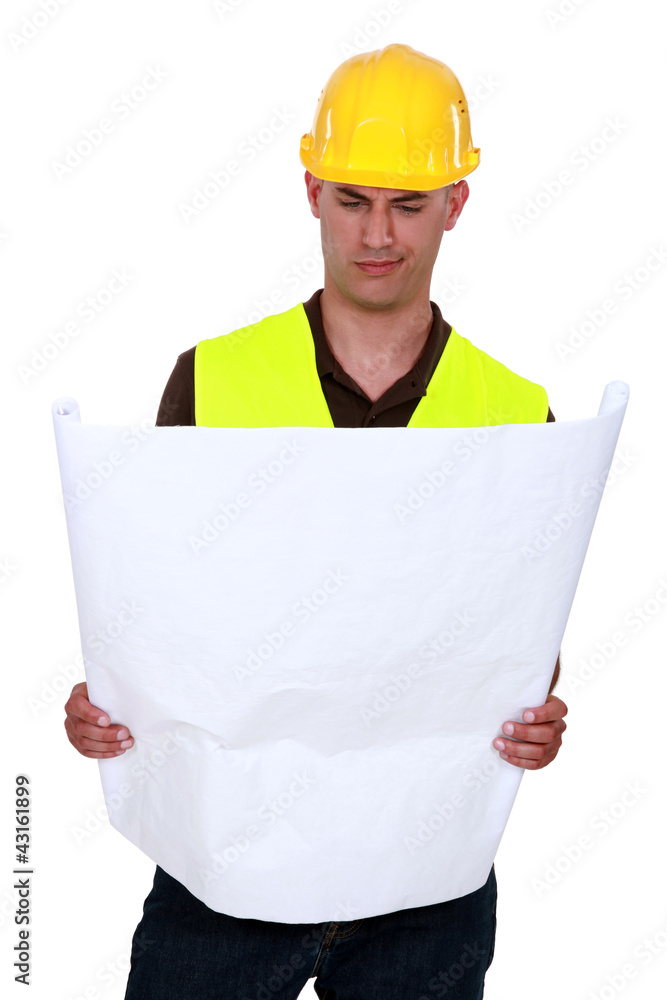 Confused tradesman looking at a technical drawing Confused tradesman looking at a technical drawing