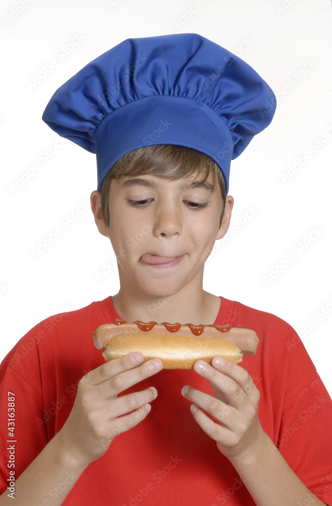 Niño chef sujetando un hotdog,comiendo perro caliente. Niño chef sujetando un hotdog,comiendo perro caliente.