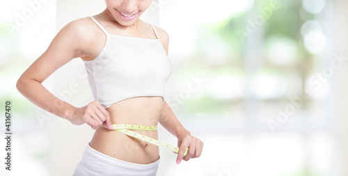 Woman smile measuring shape of waist