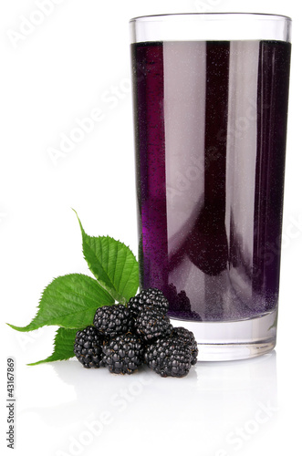 ripe blackberry with green leaf and juice in glass isolated on