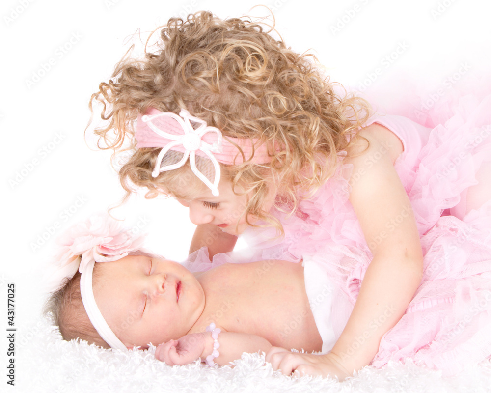 Toddler girl looking at her baby sister Toddler girl looking at her baby sister